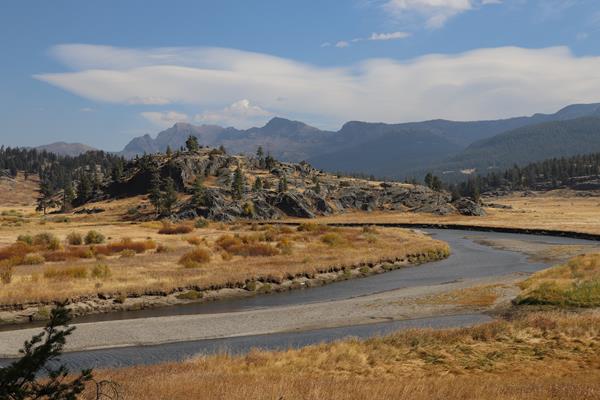 A creek meanders past a rocky outcropping.