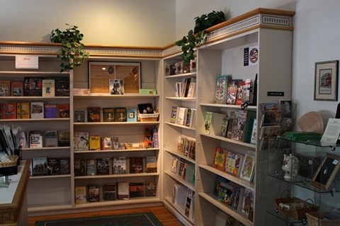 Shelving lined with books, souvenirs, postcards, soaps, and more gifts