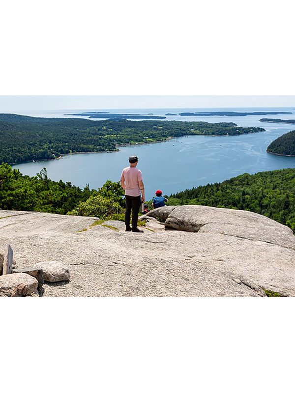 Visitors overlook islands from a mountain summit.