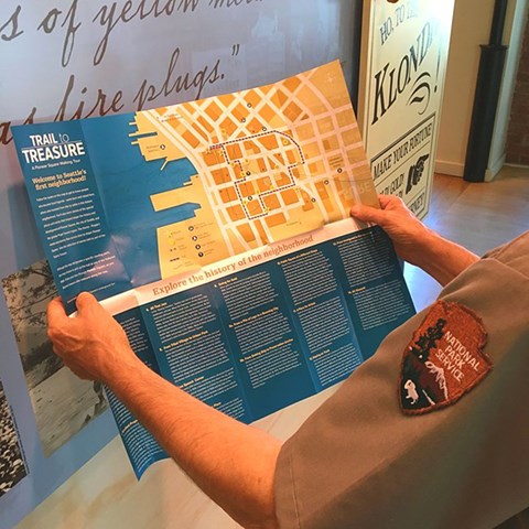Ranger holding Trail to Treasure Walking Tour map.
