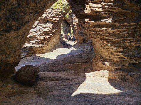 2 hikers hike up a tunnel formation