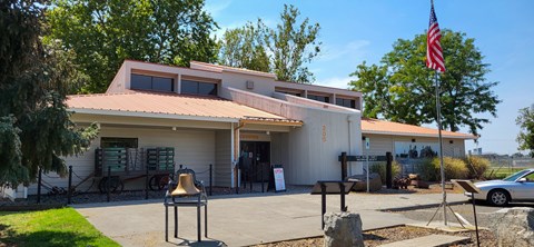 Color photograph of a wooden building with the word ‘Museum’ on its glass entrance doors.