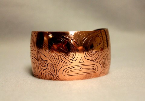 A copper bracelet with stylized engraving