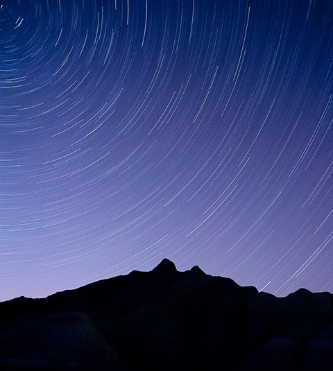 stars whir around the silhouette of a badlands butte in a circular motion