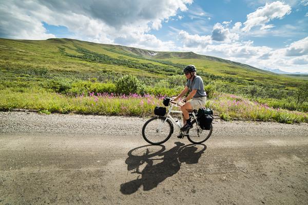 a person riding a bicycle on a dirt road