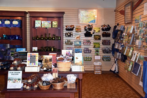 Books and other merchandise arrange on a tables and shelves.