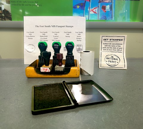 Five rubber stamps sitting at a wood stamp station in front of black ink images of each stamp.