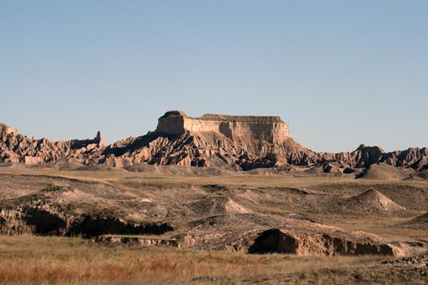 a large, flat table stands out from similarly brown badlands buttes.