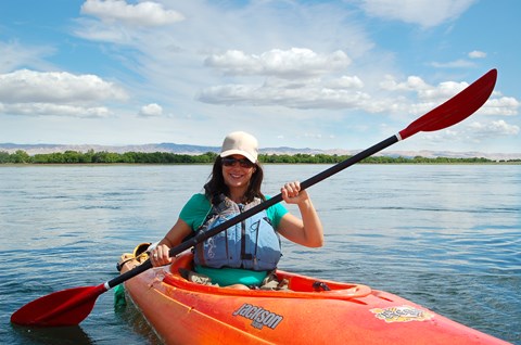 Color photograph of a kayaker on a major river