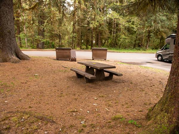 A picnic table near some dumpsters