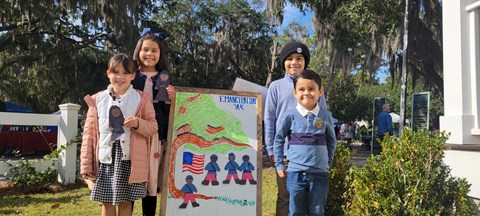 A group of four kids with their Junior Ranger badges and crafts.
