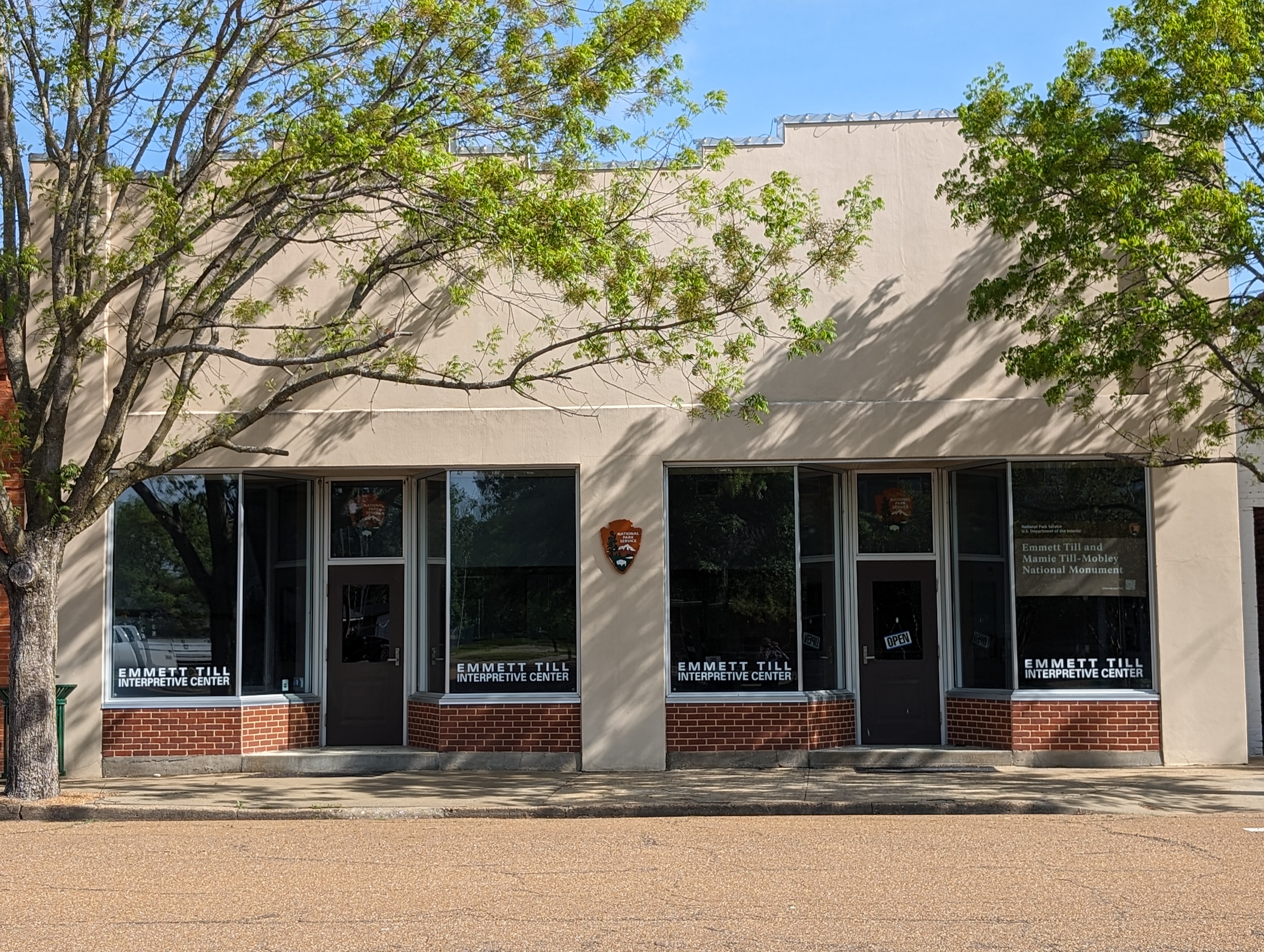 exterior of a tan building framed by two trees