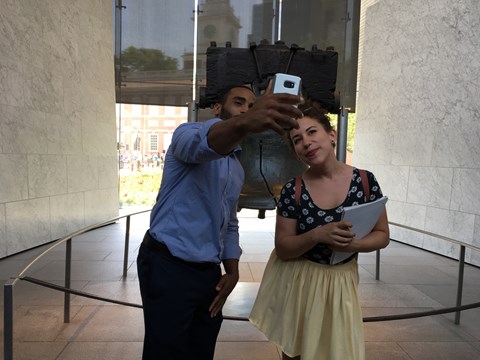 A man and a woman take a selfie photo in front of the Liberty Bell.