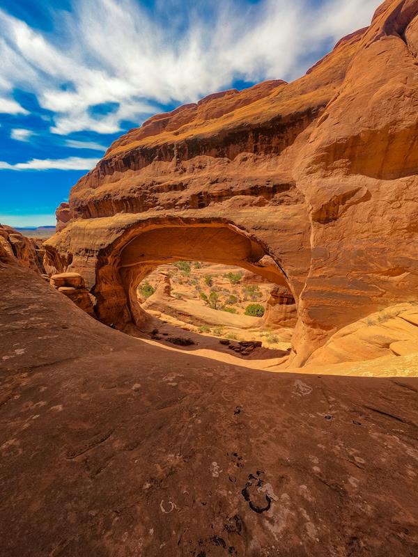 A stone arch opening frames a view of the valley below