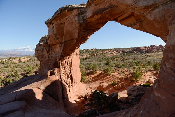 A stone arch frames a view of the landscape below