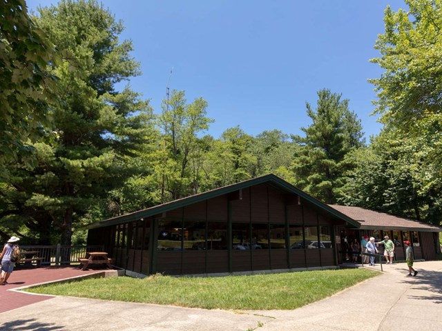 A rustic dark brown wood-sided building with dark green trim.