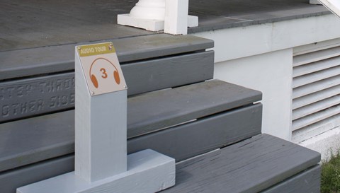 a sign on blue stairs reads 3 and has headphones