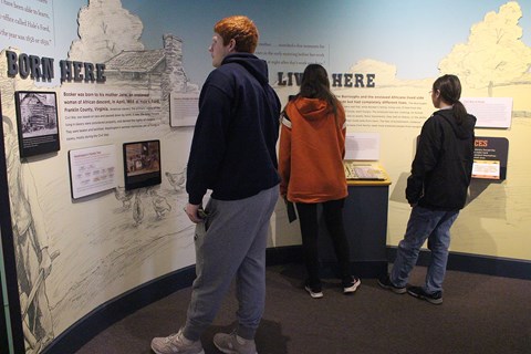 A group of visitors reading at an exhibit