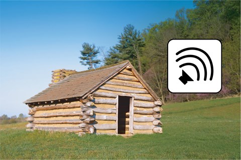 a log hut with flowering trees and a graphic showing sound lines emitted by a speaker