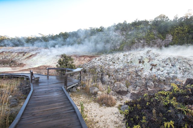 Steam rises from mineral deposits in front of a boardwalk