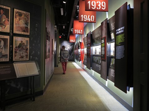 A passage with graphic panels, framed images, and exhibit cases.