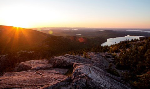 view of a lake at sunset from a mountain summit