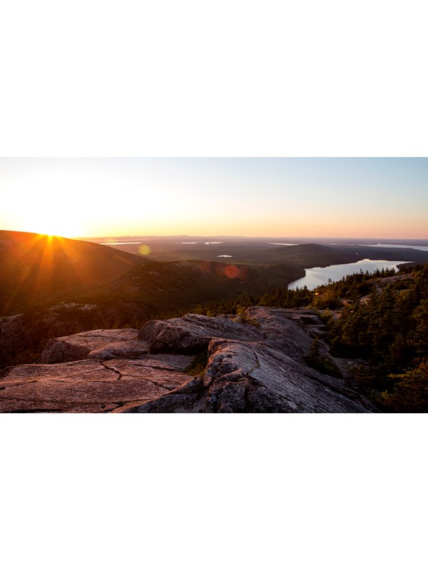 view of a lake at sunset from a mountain summit