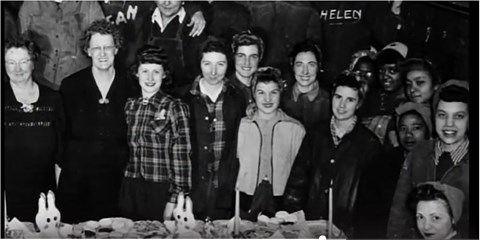 Group of women Navy Yard workers standing side by side, smiling towards the viewer.