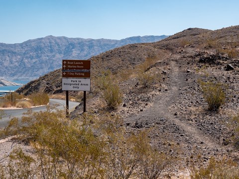 A trail next to a sign.