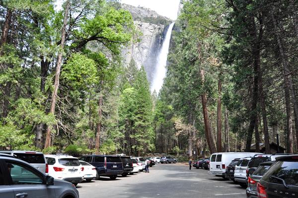 Cars parked in the lot with the waterfall visible in the background