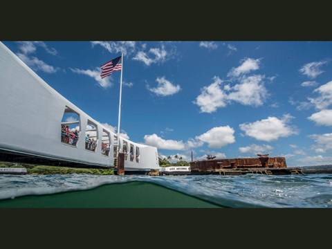 Visitors look through the open windows down to the ship below the surface.
