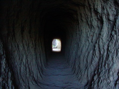 Natural light luminating the walls inside a manmade rock tunnel