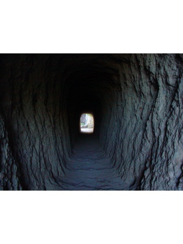 Natural light luminating the walls inside a manmade rock tunnel