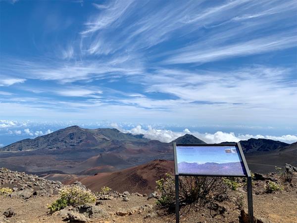 A sign at an overlook viewing the volcanic valley.