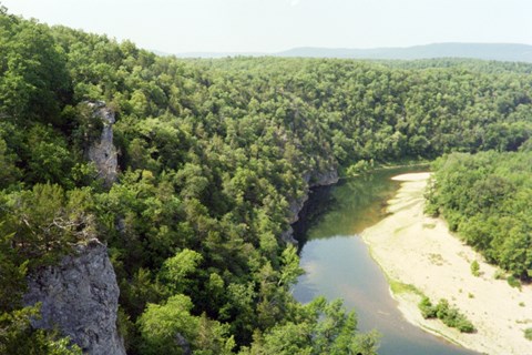 view of river from above with green trees along both sides of the water