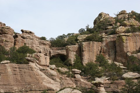 Rock formations with a natural bridge featured.
