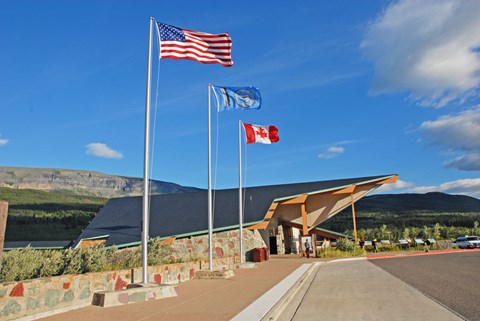 Flagpoles in front of modern building with exaggerated roofline