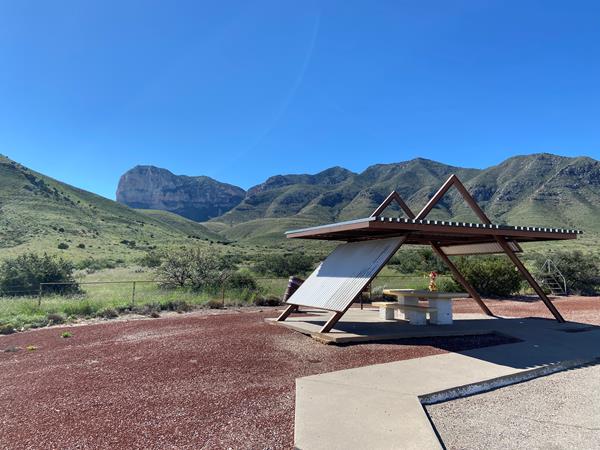 A roadside picnic table stands before a desert mountain vista
