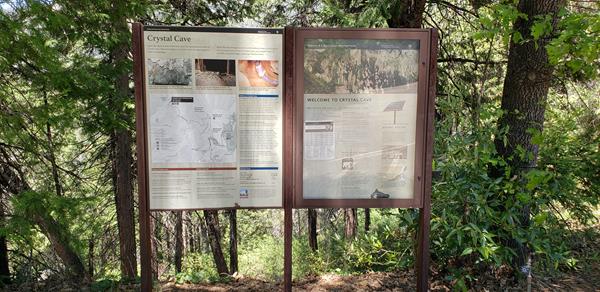 Two upright panels provide Crystal Cave trail orientation and historical information.