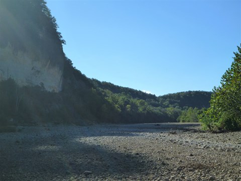 grey gravel with shadow from tall grey bluff at left