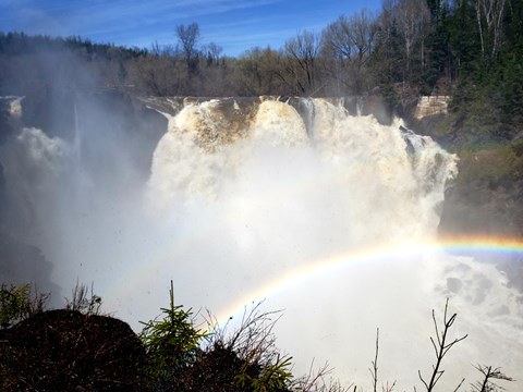 A waterfall with a rainbow in front