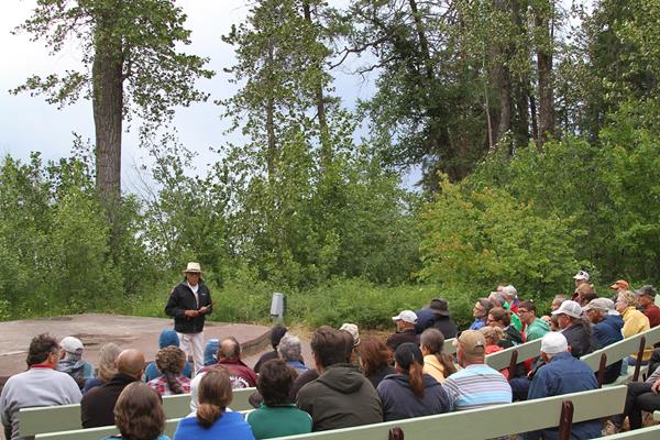 Tribal member addresses crowd seating on benches