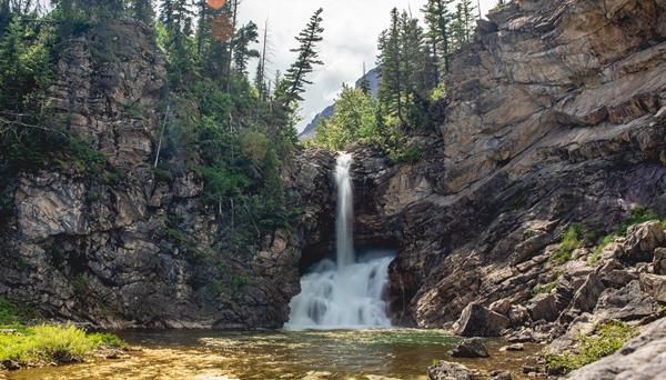 A large waterfall surrounded by rocks and trees.
