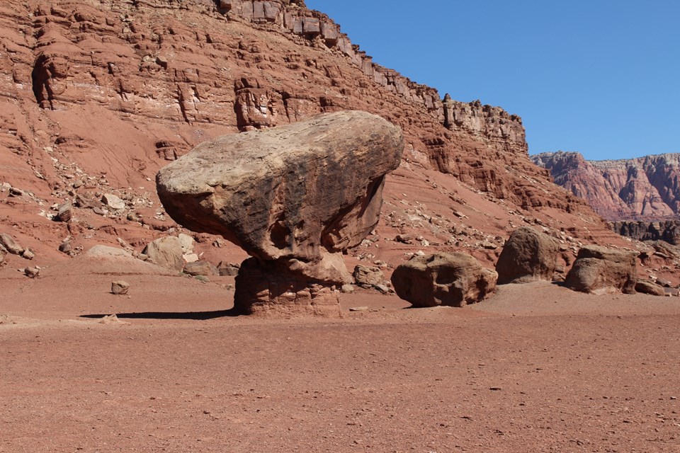 Large bolder balanced on top on small compressed rock.