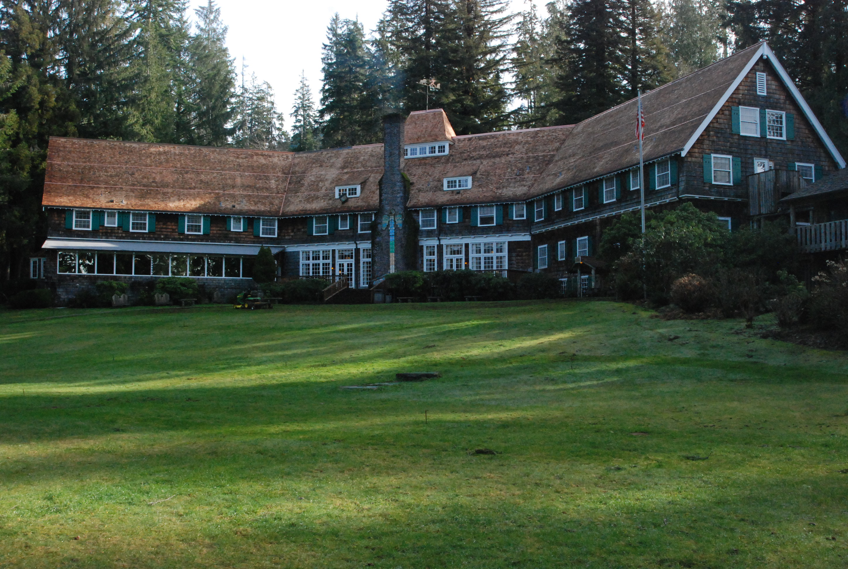 A large wooden lodge building with a sprawling lawn.
