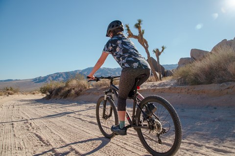 A person rides a bike down an open dirt road