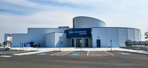 White modern museum with blue entryway and white lettering: “LIGO Exploration Center.”