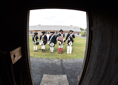 Out of a doorway, you can see several Continental soldiers standing in a line, facing away from you.