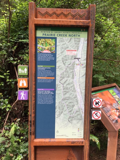 A large metal sign with information about the nearby trails