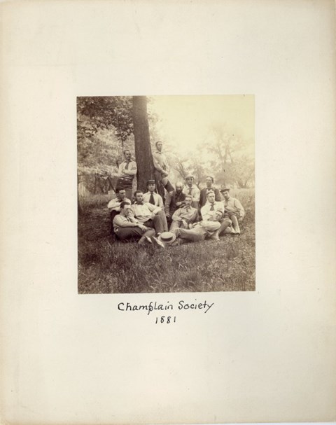 a group of young men pose in front of a tree